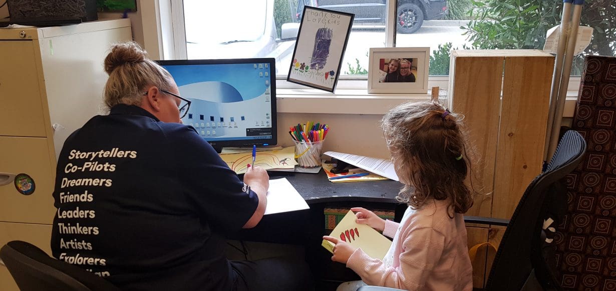 Educator and child writing letters to friends at home