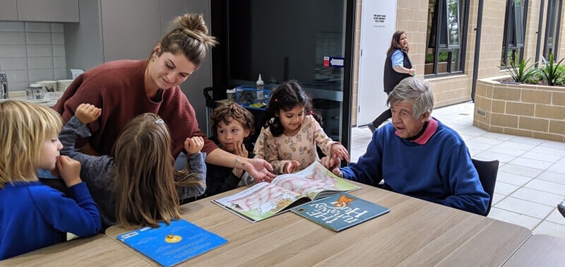 Children and Educator visiting aged care facility, playing games with resident