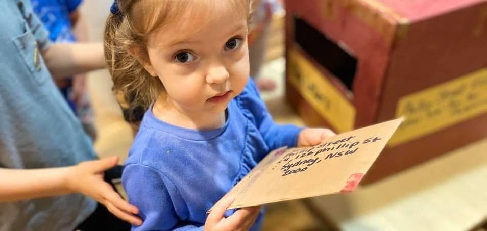 child holding handwritten letter for pen pal program