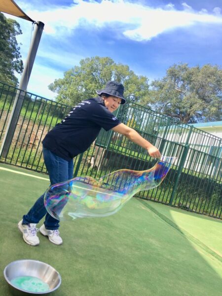 Educator making giant bubbles outdoors