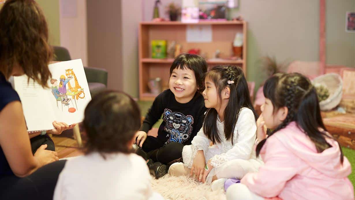 Children from Guardian George St listening to Educator read book