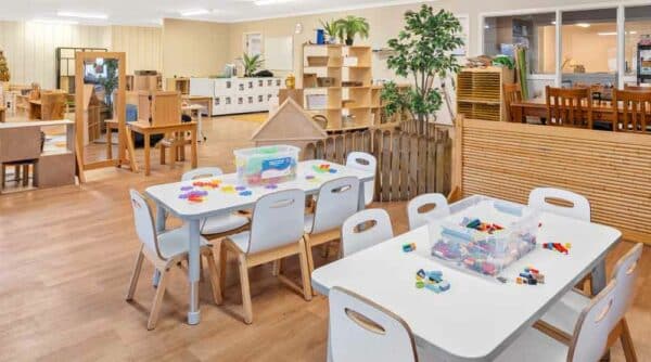Bright and engaging learning space at Guardian Childcare Essendon featuring tables set up for play-based learning activities.