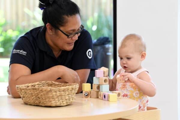 Educator playing blocks with baby. Guardian